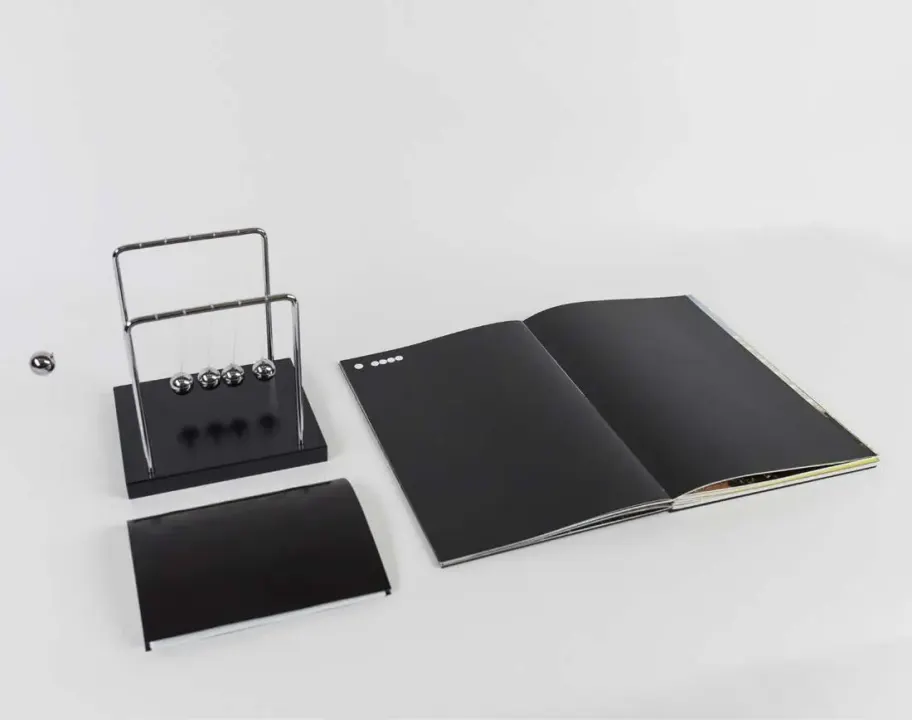 A Newton’s cradle beside the Counterforce publication and stationery