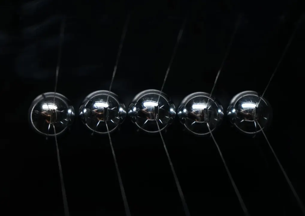 A spread with a Newton’s cradle on black