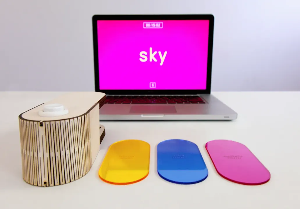 Epilepsy: the screen says ‘sky’; yellow, blue and pink acrylic cards on the table